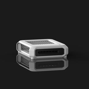 Op de afbeelding: Een wit en zwart rechthoekig elektronisch apparaat met een mesh-bovenkant en een reeks sleuven aan de voorkant. Het apparaat rust op een reflecterend oppervlak, waardoor een spiegeleffect ontstaat tegen een zwarte achtergrond.