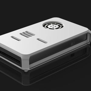 Op de afbeelding: Een wit rechthoekig elektronisch apparaat met een afgerond frame, ventilatieopeningen en een cirkelvormige ventilator aan de bovenkant. Het apparaat heeft een sleuf aan de voorkant en staat tegen een zwarte achtergrond. Het is waarschijnlijk een computercomponent of een vergelijkbaar technisch product.