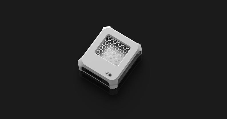 Peut inclure: Un appareil rectangulaire blanc avec une grille en nid d'abeille et un petit bouton circulaire. L'appareil a un design &eacute;l&eacute;gant et moderne, sur fond sombre. L'esth&eacute;tique g&eacute;n&eacute;rale est minimaliste et ax&eacute;e sur la technologie.