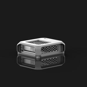 Peut inclure: Un petit appareil rectangulaire blanc avec un design g&eacute;om&eacute;trique. L'appareil pr&eacute;sente un motif en nid d'abeille sur les c&ocirc;t&eacute;s et un motif en grille sur le dessus. L'objet se refl&egrave;te sur une surface noire.