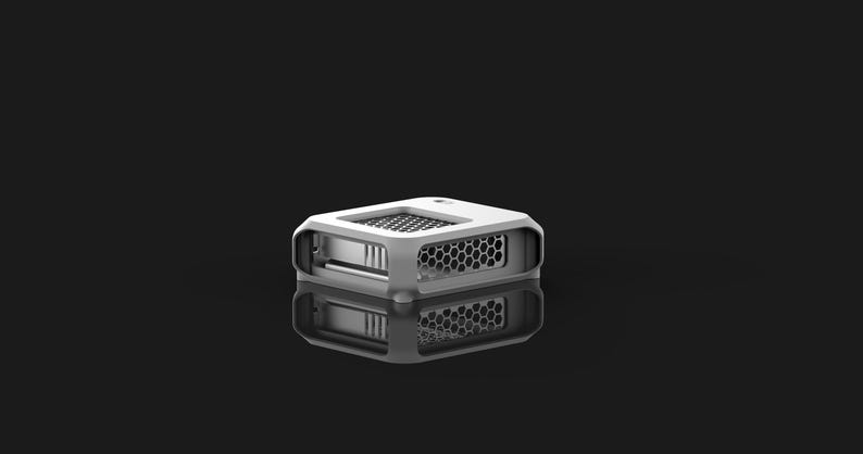 Peut inclure: Un petit appareil rectangulaire blanc avec un design g&eacute;om&eacute;trique. L'appareil pr&eacute;sente un motif en nid d'abeille sur les c&ocirc;t&eacute;s et un motif en grille sur le dessus. L'objet se refl&egrave;te sur une surface noire.