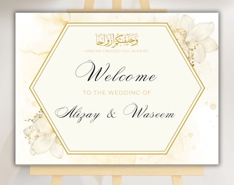 May include: A white wedding welcome sign with gold accents and floral designs. The sign features the Arabic text "وخلقتكم ازواجا" which translates to "And We Created You in Pairs." The sign also includes the text "Welcome to the Wedding of Alizay & Waseem."