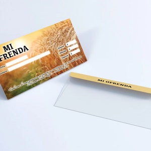 May include: A brown and yellow envelope with a field of wheat background. The envelope has the text "MI OFRENDA" printed on the front. The envelope has a clear plastic window on the front.