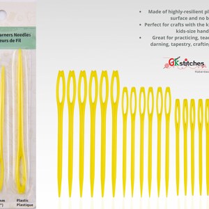 Könnte beinhalten: Satz mit drei gelben Kunststoff-Garn-Stopfnadeln, 70 mm, 82 mm und 94 mm lang. Die Nadeln sind auf einer weißen Karte verpackt mit dem Text "Yarn Darners Needles Repriseurs de Fil" und "Gkstitches Haberdashery".