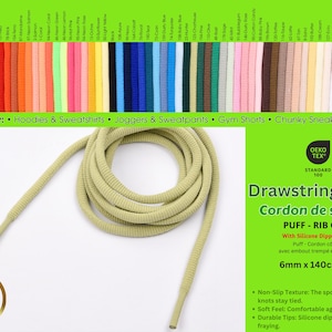 Puede incluir: Un cordón de ajuste acanalado de color verde oliva claro que mide 6mm por 140cm. El cordón cuenta con puntas sumergidas en silicona en ambos extremos. La imagen muestra una carta de colores con 60 opciones disponibles y texto del producto.