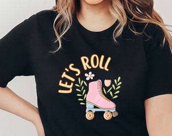 May include: Black t-shirt with the text "Let's Roll" in yellow with a pink roller skate with blue wheels and floral accents.