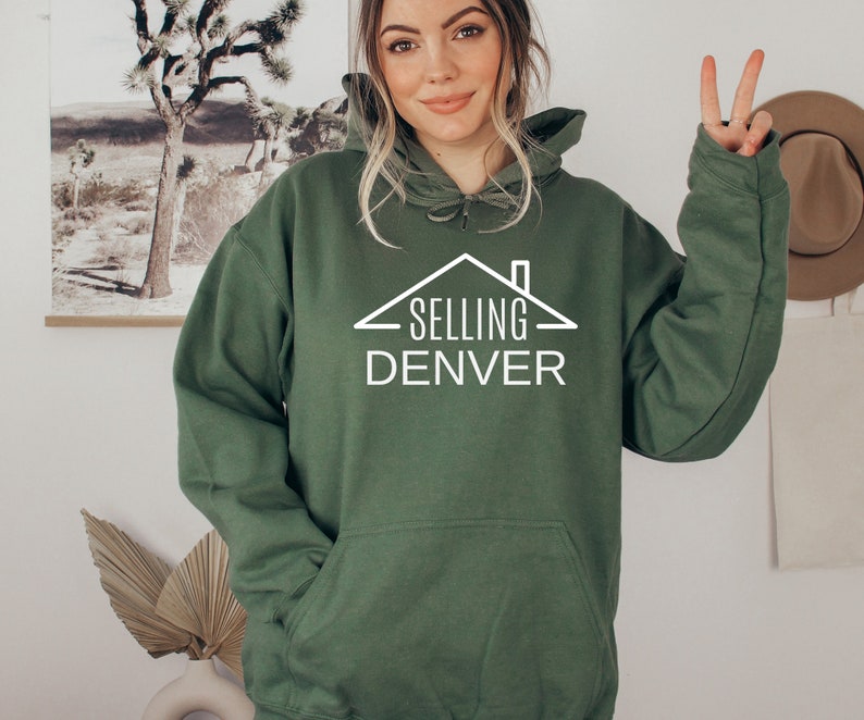 May include: A green hooded sweatshirt with a white graphic of a house with the text "SELLING DENVER" underneath.
