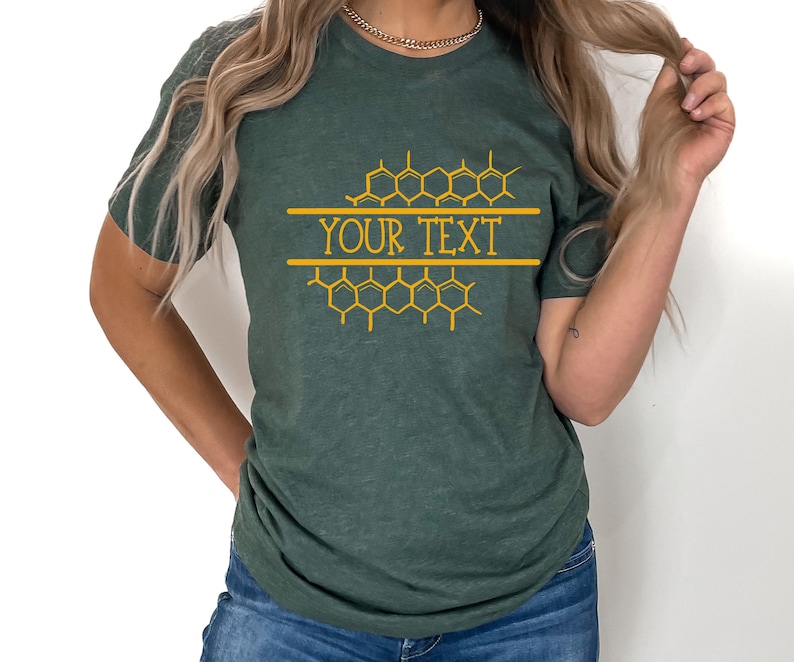 K&ouml;nnte beinhalten: Ein dunkelgr&uuml;nes T-Shirt mit einem Wabenmuster und dem Text "YOUR TEXT" in Gold.