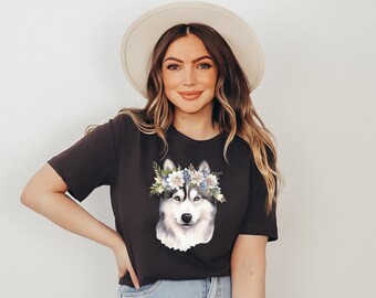 May include: A black t-shirt with a floral crown husky graphic. The husky is white and gray with blue eyes. The flowers are white, blue, and green.