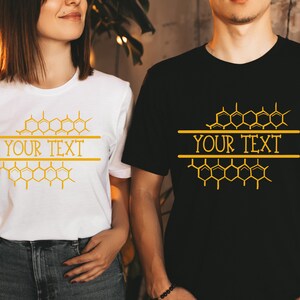 K&ouml;nnte beinhalten: Zwei T-Shirts mit einem Wabenmuster und dem Text "YOUR TEXT" darauf gedruckt. Das T-Shirt links ist wei&szlig; und das T-Shirt rechts ist schwarz.