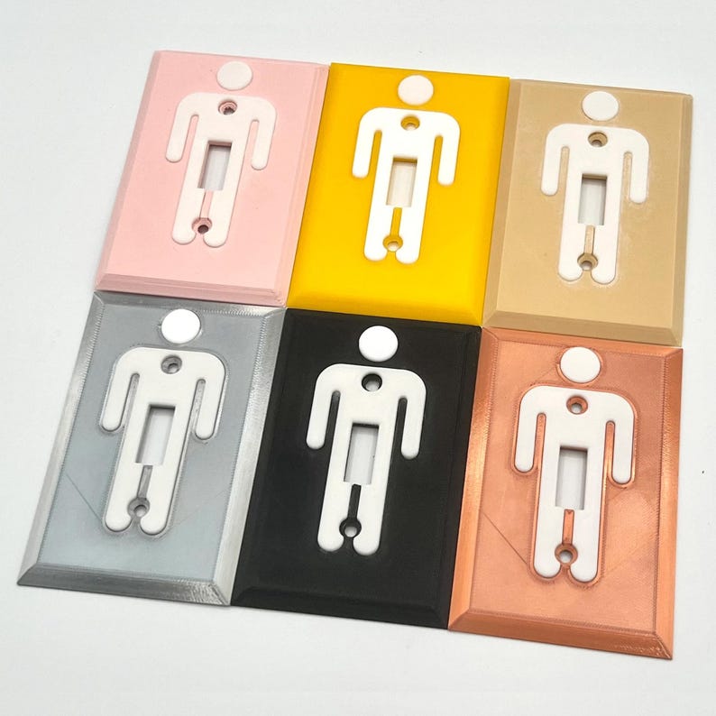 K&ouml;nnte beinhalten: Sechs Lichtschalterabdeckungen in verschiedenen Farben: rosa, gelb, beige, silber, schwarz und kupfer. Jede Abdeckung zeigt eine wei&szlig;e Silhouette einer Person mit einem Lichtschalter in der Mitte.