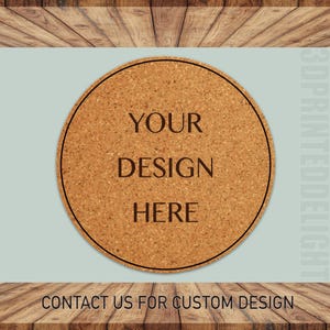 May include: A round cork coaster with a black border. The text "YOUR DESIGN HERE" is printed on the coaster. Contact us for custom design.