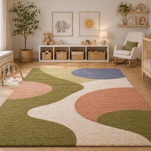 K&ouml;nnte beinhalten: Ein farbenfroher Teppich mit abstraktem Design in Gr&uuml;n-, Pfirsich-, Blau- und Cremet&ouml;nen. Der Teppich befindet sich in einem Kinderzimmer, mit einem Kinderbett, einem Schaukelstuhl und dekorativen Elementen.