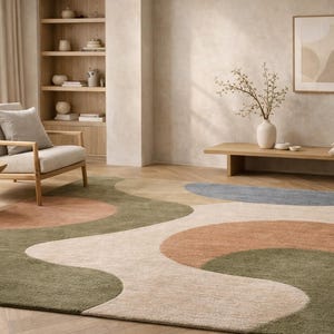 K&ouml;nnte beinhalten: Ein modernes Wohnzimmer mit einem gro&szlig;en Teppich mit abstraktem Design. Der Teppich hat ein wellenf&ouml;rmiges Muster in Gr&uuml;n-, Pfirsich-, Beige- und Blaut&ouml;nen. Der Raum umfasst auch einen Holzstuhl, einen Beistelltisch und ein Holzregal mit Dekorationsartikeln.