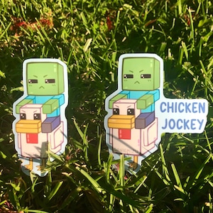May include: Two green Minecraft zombie stickers riding a white chicken with the text "CHICKEN JOCKEY" on a green grassy background.