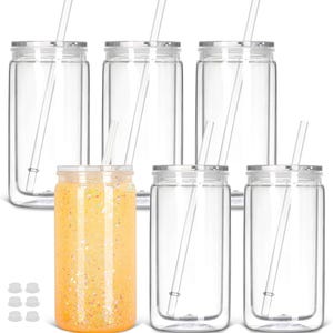 Peut inclure: Ensemble de six gobelets en verre transparent avec couvercles argentés et pailles transparentes. Un gobelet est rempli d'une boisson orange avec des paillettes. Six bouchons en silicone blancs sont en bas.