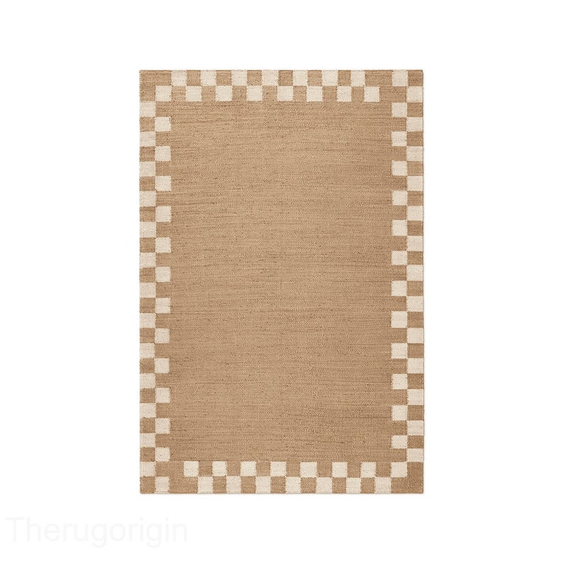 K&ouml;nnte beinhalten: Rechteckiger beigefarbener Teppich mit einem Rand aus abwechselnd beigen und braunen Quadraten. Der Teppich hat eine gewebte Textur und ein schlichtes, geometrisches Design. Geeignet f&uuml;r ein Wohn- oder Schlafzimmer.