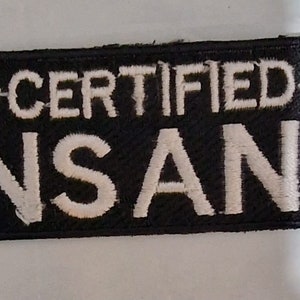 Puede incluir: Parche bordado en blanco y negro con el texto "~CERTIFIED~ INSANE" en letras blancas.