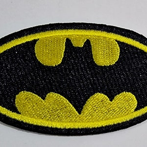 Könnte beinhalten: Ein gestickter Aufnäher mit dem Batman-Logo in Schwarz und Gelb.