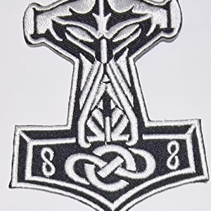 Könnte beinhalten: Schwarz-weiß gestickter Patch von Thors Hammer, Mjolnir, mit einem Knotendesign in der Mitte. Der Hammer hat einen silbernen Umriss und der Knoten ist silber.
