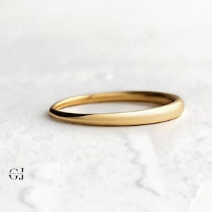 Könnte beinhalten: Ein einfacher Goldring mit einer glatten, abgerundeten Oberfläche.