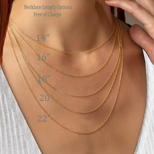 K&ouml;nnte beinhalten: Nahaufnahme eines Models, das eine goldene Kettenkette tr&auml;gt. Die Kette wird in f&uuml;nf verschiedenen L&auml;ngen gezeigt: 35,5 cm, 40,6 cm, 45,7 cm, 50,8 cm und 55,9 cm. Der Text "Necklace Length Options Free of Charge" wird &uuml;ber dem Bild angezeigt.