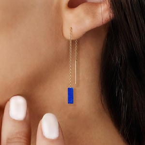 May include: Gold chain earrings with a blue rectangular stone pendant.