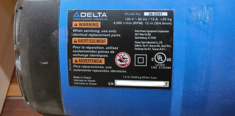 May include: A blue and black Delta 12-inch Sliding Miter Saw with a warning label in English, French, and Spanish. The label states to use only identical replacement parts when servicing the saw. The saw is UL listed and has a model number of 26-2251.