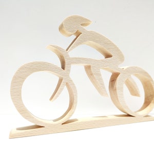 Peut inclure: Sculpture en bois repr&eacute;sentant un cycliste sur un v&eacute;lo. La sculpture est faite de bois clair et pr&eacute;sente un design minimaliste. Les roues et le cadre du v&eacute;lo sont stylis&eacute;s, et le cycliste est en position de conduite. La sculpture est mont&eacute;e sur une base rectangulaire.