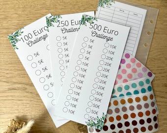 May include: Three white cards with green foliage designs and black text. The cards are labelled "100 Euro Challenge", "250 Euro Challenge", and "500 Euro Challenge". Each card has a list of euro amounts with checkboxes next to them. The amounts are 5, 10, 20, and 50 euros.