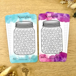 Könnte beinhalten: Zwei druckbare Sparglas-Tracker mit Aquarellhintergründen. Die Gläser sind in Schwarz umrandet und mit Euro-Symbolen gefüllt. Der Text "Sparglas" befindet sich oben auf jedem Tracker. Der Text "Ziel =" befindet sich unten auf jedem Tracker.