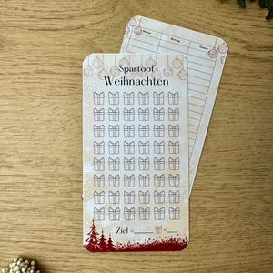Può includere: Un tracker di risparmio natalizio bianco e rosso con un design festivo. Presenta una griglia di 60 scatole regalo da spuntare man mano che si risparmia. Il tracker include anche una sezione per impostare un obiettivo di risparmio.