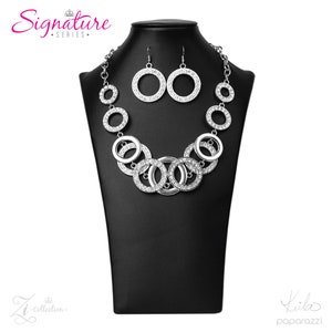 May include: A silver-colored necklace and earring set displayed on a black mannequin. The necklace features multiple interconnected circles, some adorned with rhinestones. The earrings are matching circular drops. The words "Signature Series" are visible.