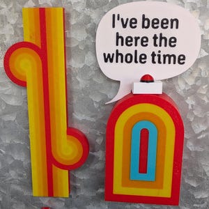 May include: A collection of colorful magnets with a retro design. Includes a red and yellow abstract shape, a red and yellow arch with a blue center, a sword with the text "Samalamadingdong", and a speech bubble that says "I've been here the whole time."