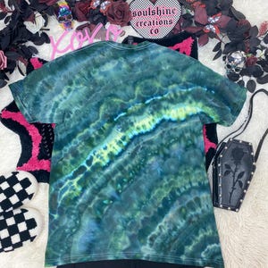 May include: Green tie-dye t-shirt with a swirling pattern. The shirt is made of a soft, comfortable material and has a relaxed fit.