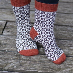 Puede incluir: Un par de calcetines de color marrón y blanco con un puño de color óxido. Los calcetines están hechos de un tejido suave y de punto.