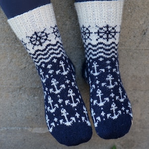 Puede incluir: Un par de calcetines de punto azul y blanco con un patrón de ancla. Los calcetines tienen un puño blanco y un patrón de onda azul y blanco.