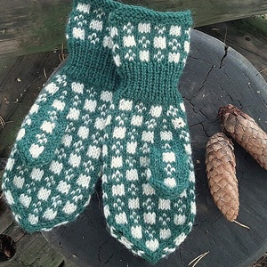 May include: A pair of green and white knitted mittens with a checkered pattern. The mittens are sitting on a wooden surface.