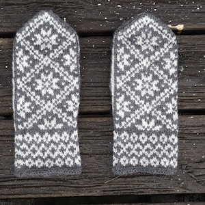 May include: A pair of gray and white knitted mittens with a snowflake pattern.