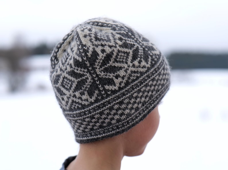 K&ouml;nnte beinhalten: Eine gestrickte M&uuml;tze in Schwarz und Wei&szlig; mit geometrischem Muster.