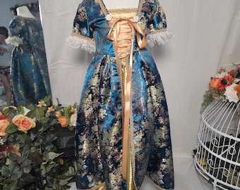 Vestido rococó para niña: vestido azul con estampado floral y enagua dorada.