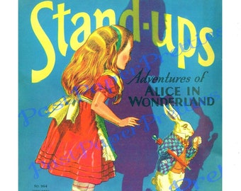 May include: A vintage stand-up paper doll set featuring Alice from Alice in Wonderland. The set includes Alice in a red dress and a white rabbit holding an umbrella. The paper doll set is titled "Stand-Ups Adventures of Alice in Wonderland" and has the number 964 printed on it.