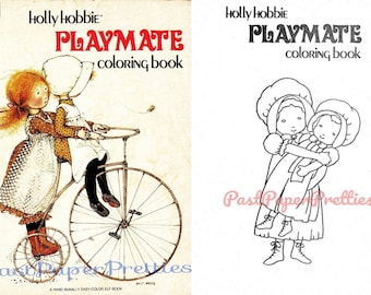 May include: A vintage coloring book featuring a black and white illustration of two girls, one carrying the other. The book cover has the title "PLAYMATE coloring book" and the author's name "Holly Hobbie".