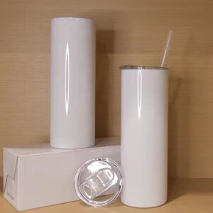 May include: Two white sublimation tumblers with lids and a straw. The tumblers are on a white box with a clear lid.