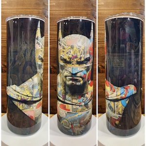 May include: A stainless steel tumbler with a black background and a collage of comic book panels featuring Batman. The panels are mostly in shades of yellow, red, blue, and green.