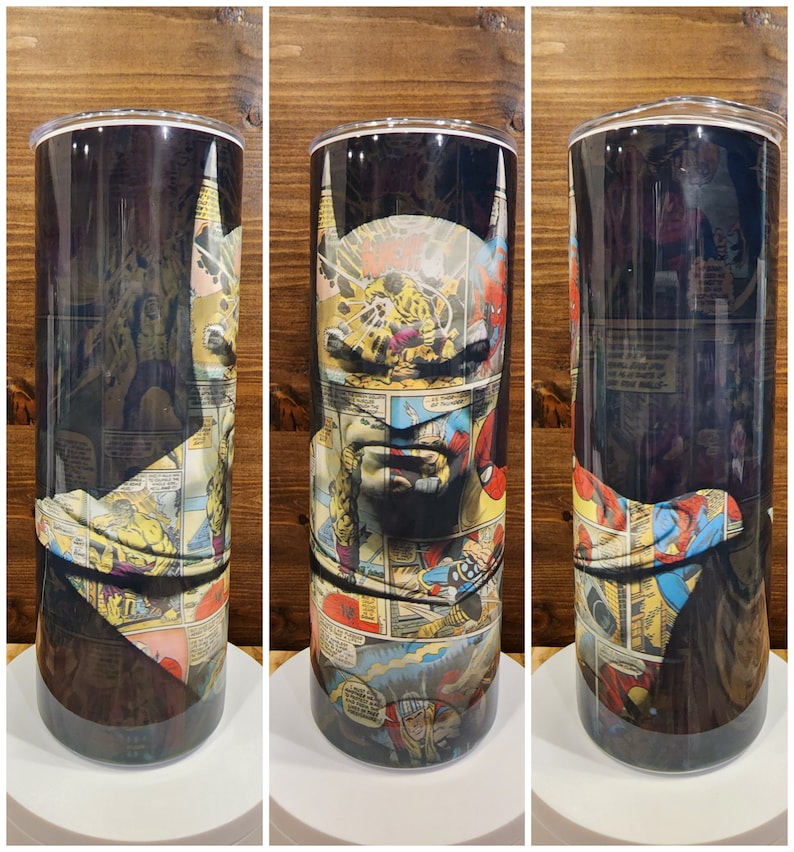 May include: A stainless steel tumbler with a black background and a collage of comic book panels featuring Batman. The panels are mostly in shades of yellow, red, blue, and green.