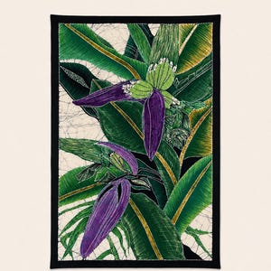 May include: A rectangular textile wall hanging featuring a batik-style illustration of vibrant purple banana blossoms and lush green banana leaves. The design is set against a cream-colored background with a crackled texture and a solid black border.
