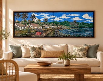May include: A long rectangular wall art piece featuring a vibrant batik-style landscape painting. The scene depicts a coastal village with white houses, palm trees, a red vehicle on a dirt road, and green mountains under a bright blue sky with clouds.