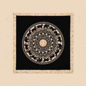 May include: A black and white batik textile featuring a circular design with animal figures. The central motif is surrounded by concentric circles and a decorative border. The outer border is a light beige color.