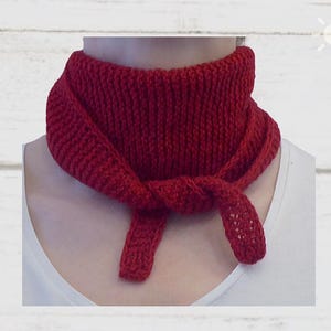 Könnte beinhalten: Ein gestrickter, dunkelroter Schal ist vorne geknotet. Der Schal ist um den Hals gewickelt und hat ein strukturiertes Aussehen. Der Text "Dunkelrot-uni" befindet sich am unteren Rand des Bildes.